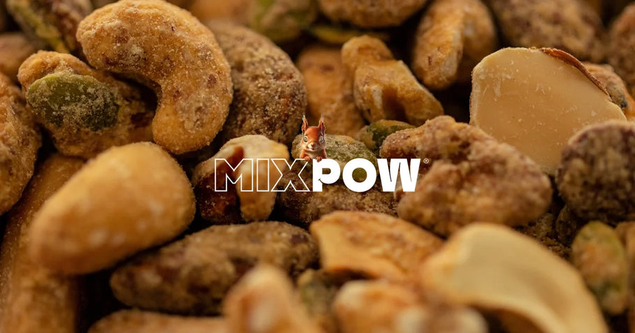 Assortiment de fruits secs peu caloriques — pruneaux, abricots secs, amandes — disposés sur fond blanc