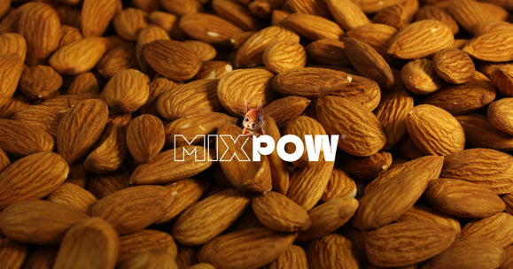 Amandes entières en gros plan — base du lait végétal maison face aux briques du commerce
