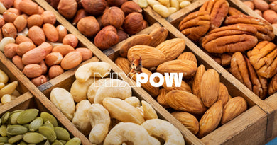 Boîte compartimentée de fruits secs par origine — cajou, amandes, noisettes, pécan et graines de courge