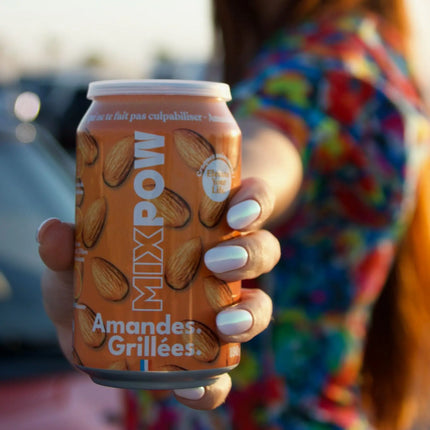 Main tenant canette Mixpow amandes grillées en extérieur — snack fruits secs pratique nomade