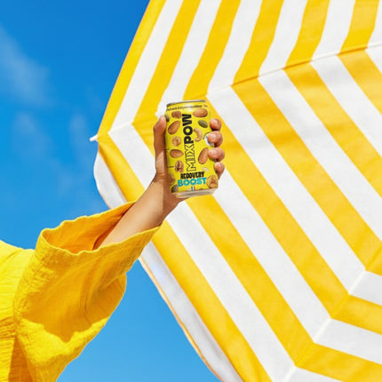 Main tenant canette Mixpow Recovery Boost sous parasol — snack sport récupération fruits secs