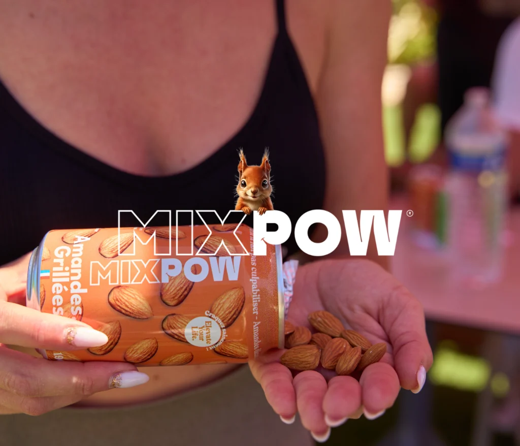 Femme tenant une canette d’amandes grillées Mixpow, versant les fruits secs dans sa main pour une collation à emporter saine et pratique.